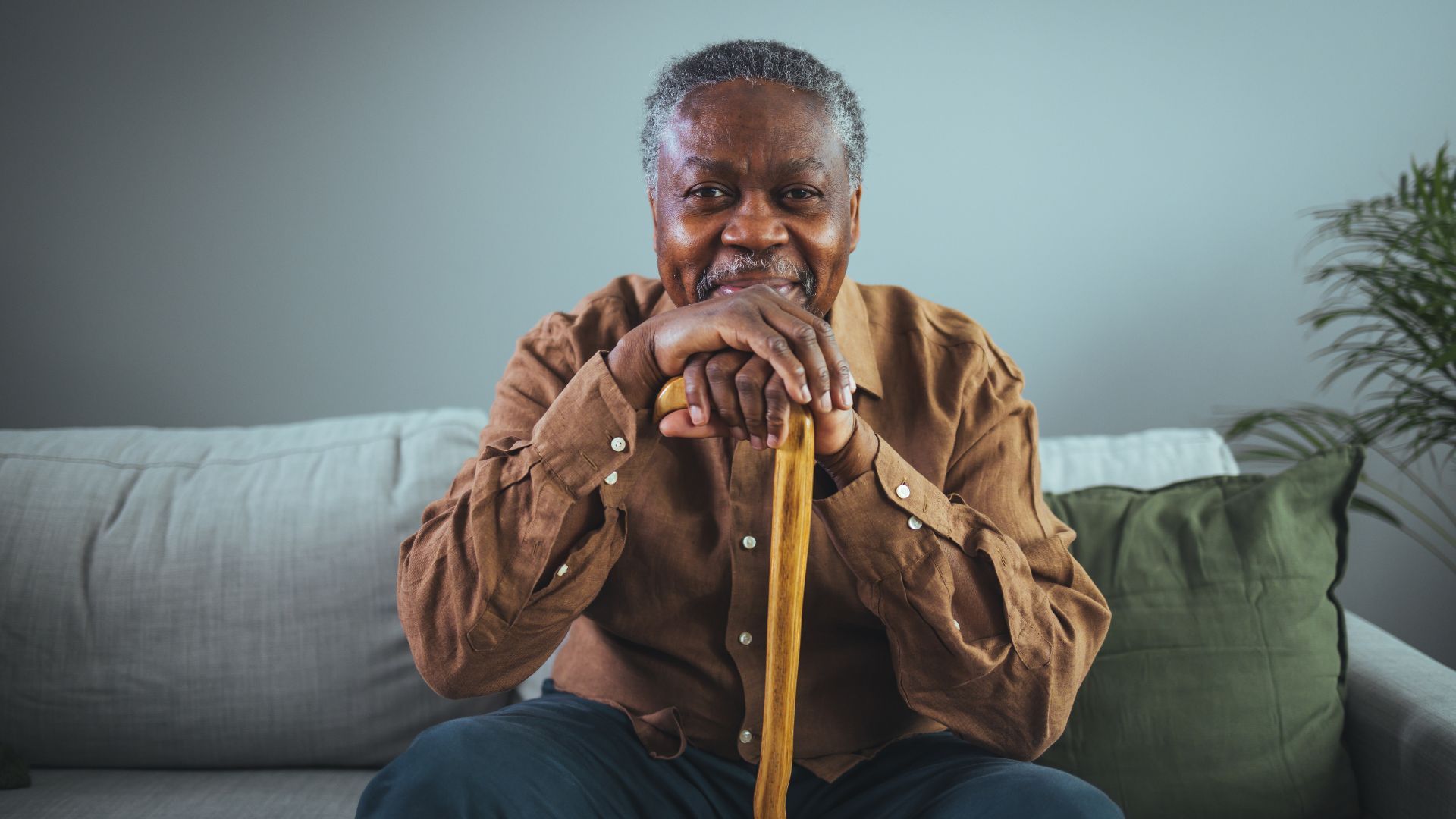 Elderly black man smiling in his living room